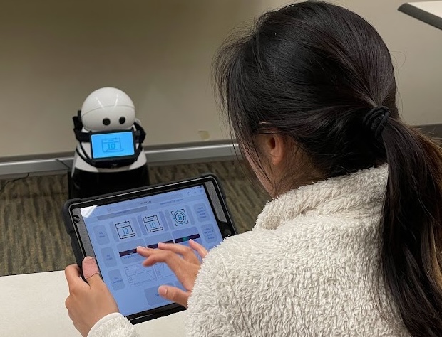 A user uses an ipad to design signals for a robot